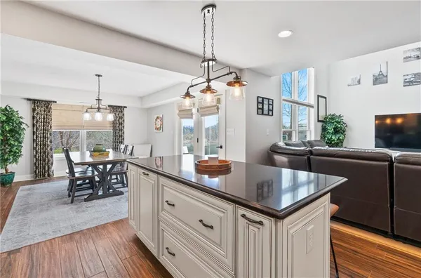 a kitchen with granite countertop a center island a dining table and chairs