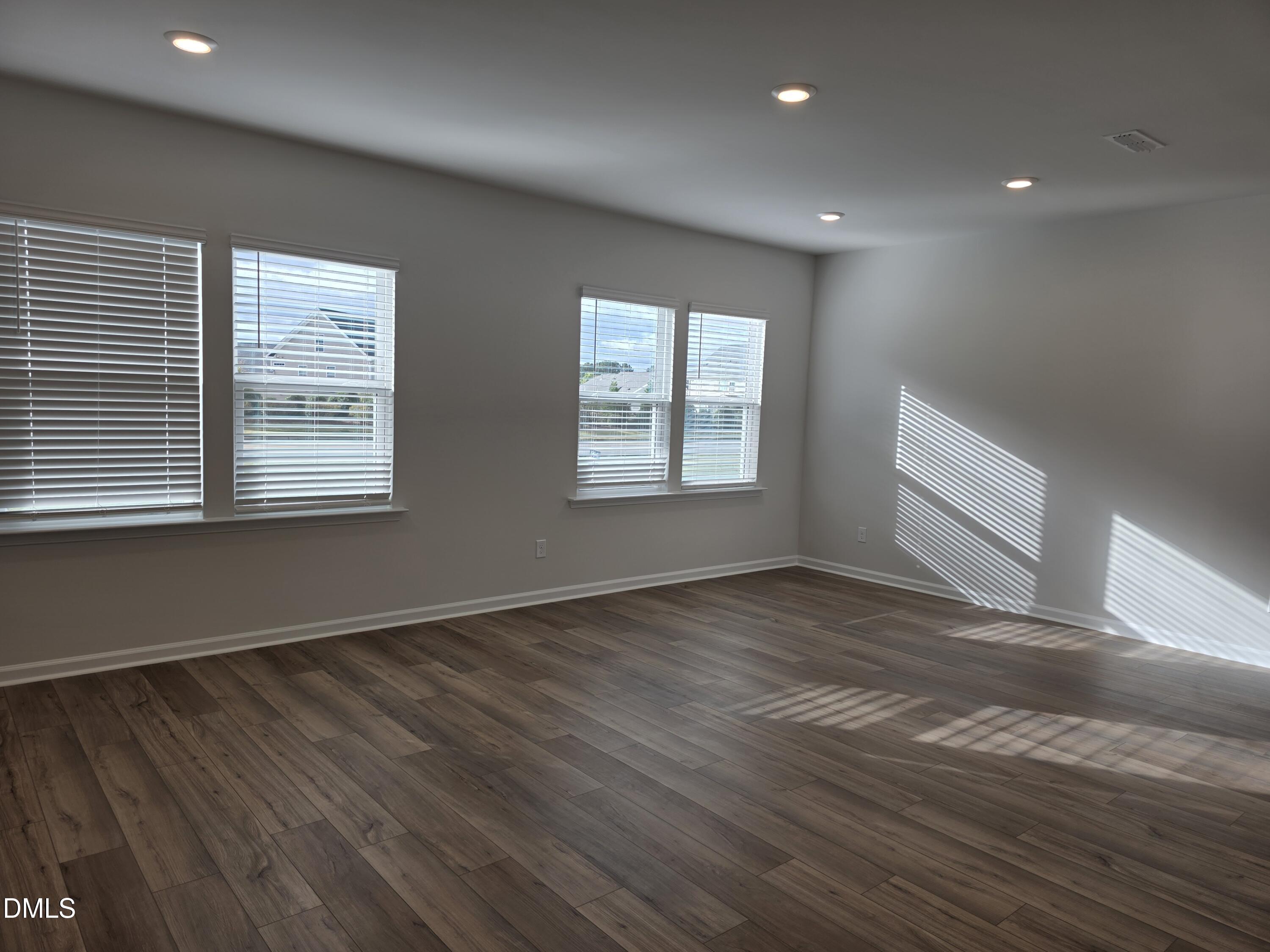 2540 Olive Chapel Road Apex, NC 27502 - Photo 5 of 27 a view of an empty room with wooden floor and a window