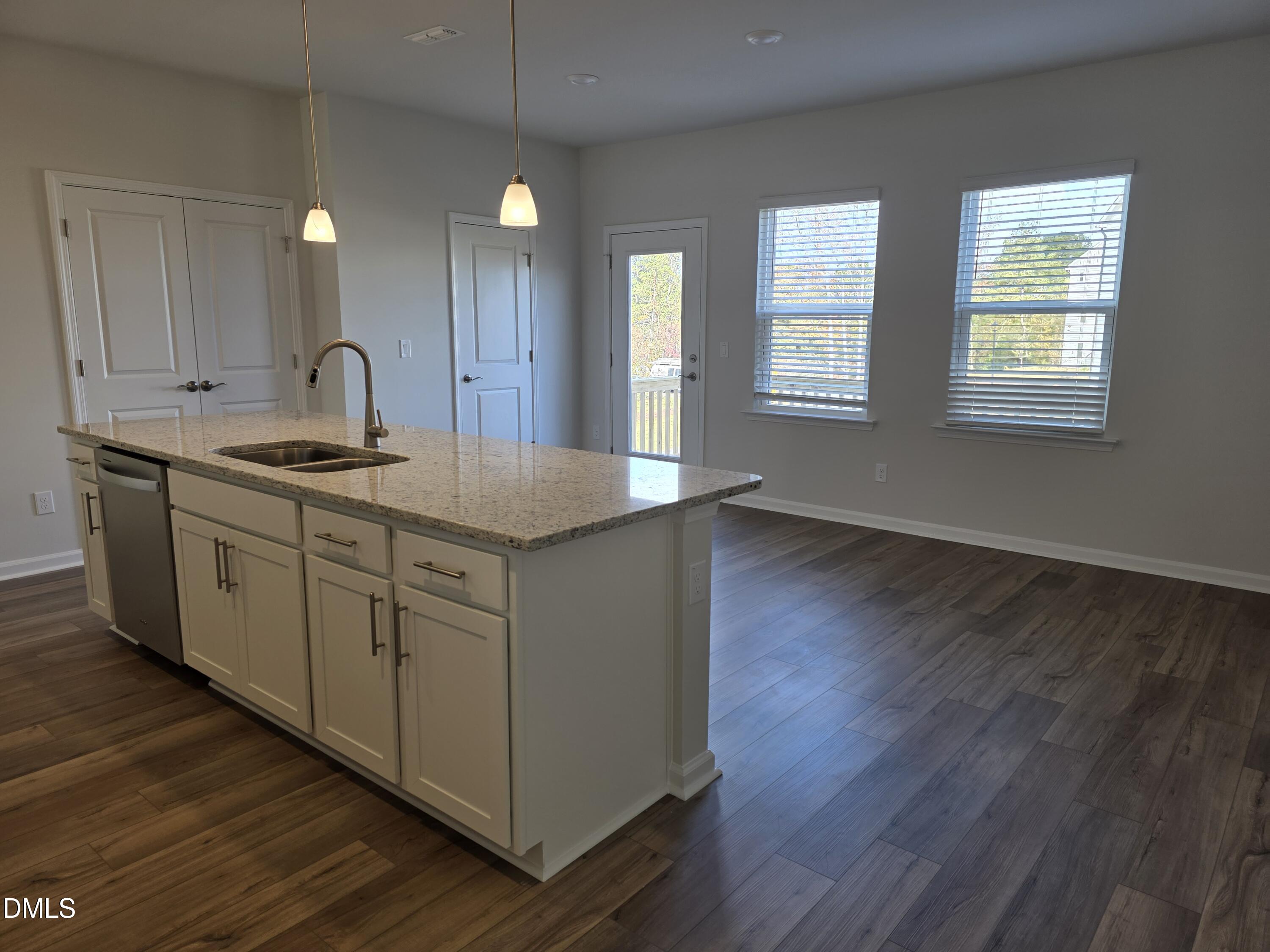 2540 Olive Chapel Road Apex, NC 27502 - Photo 7 of 27 a kitchen with stainless steel appliances granite countertop a sink cabinets and wooden floor