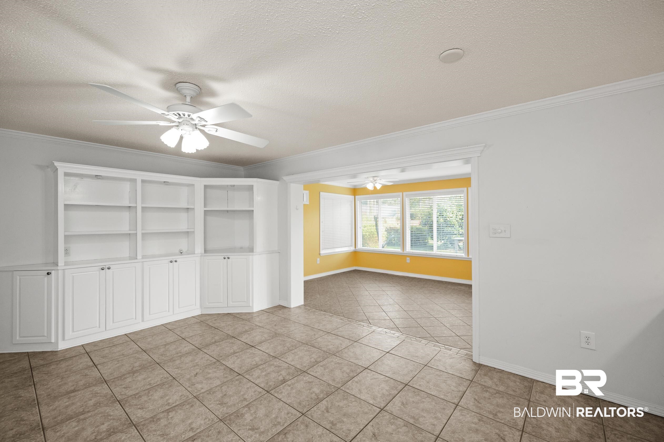 303 West Palm Avenue Foley, AL 36535 - Photo 8 of 32 Tiled spare room featuring ornamental molding, a textured ceiling, and ceiling fan