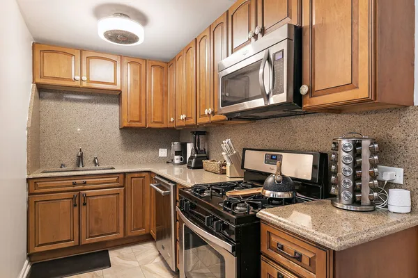a kitchen with stainless steel appliances granite countertop a stove and a microwave