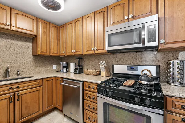 a kitchen with stainless steel appliances granite countertop a stove and a microwave