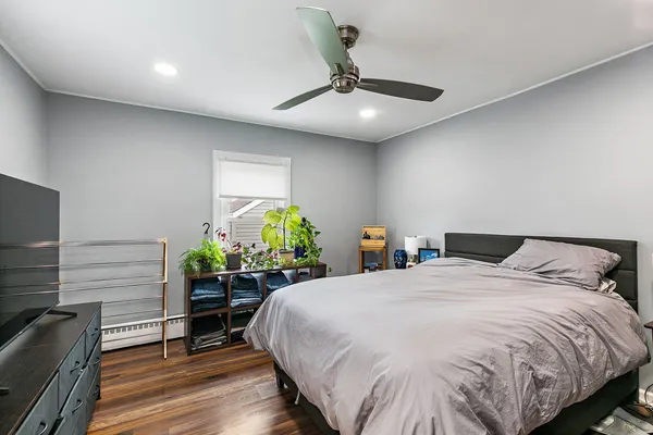 a bedroom with a bed table and flowerpot