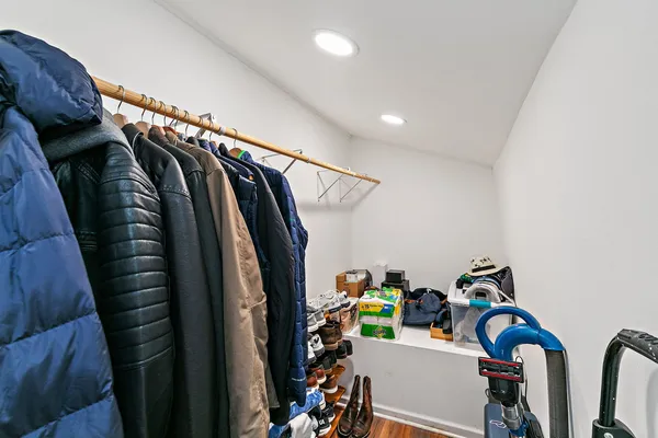 a view of walk in closet with clothes and shoes