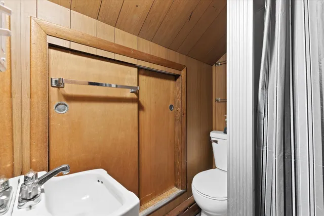 a bathroom with a toilet a sink and shower