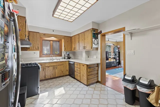 a large kitchen with a stove a sink dishwasher and cabinets