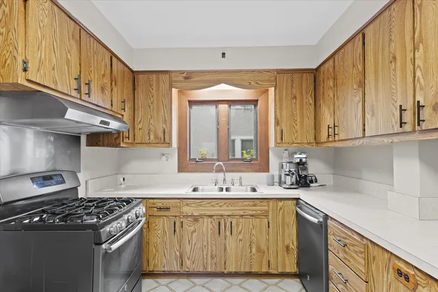 a kitchen with granite countertop a sink stove and cabinets