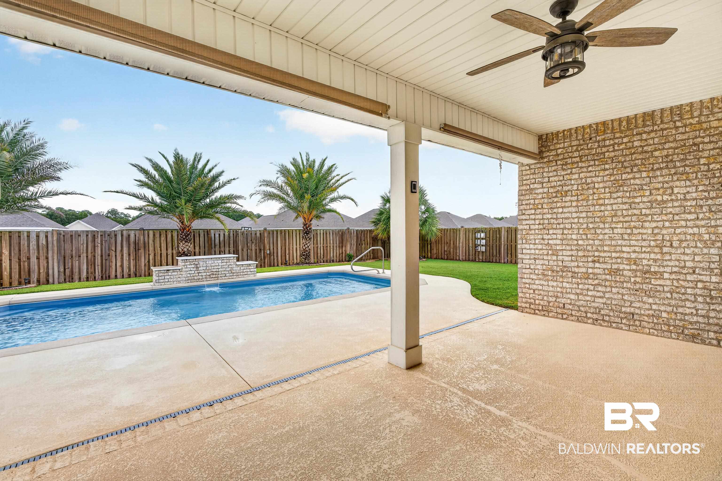 1724 Partridge Street Foley, AL 36535 - Photo 49 of 62 Covered patio with a ceiling fan and recessed lighting, overlooking a rectangular swimming pool with a stone water feature