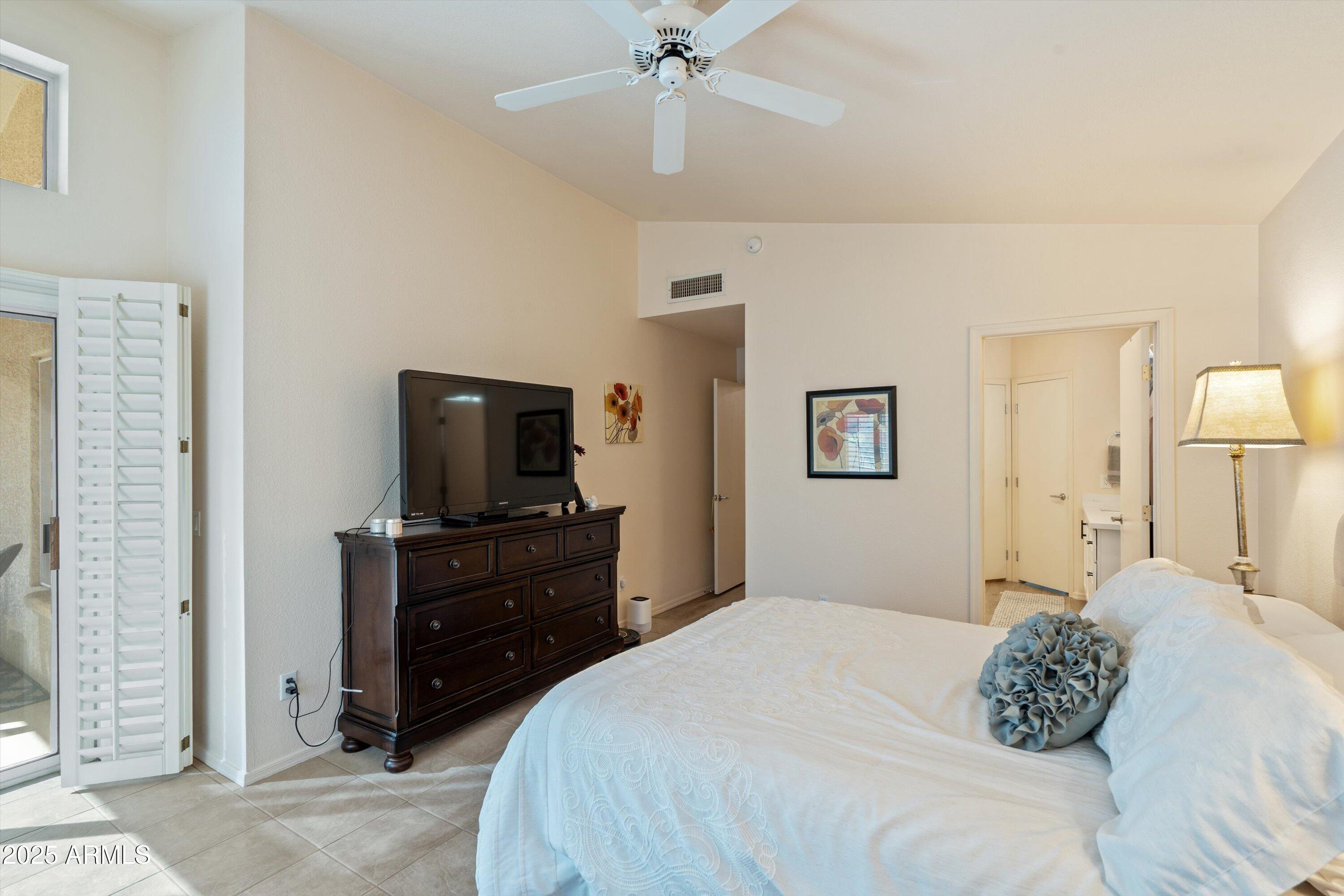 15415 West Merrell Street Goodyear, AZ 85395 - Photo 13 of 33 a bedroom with a bed and a flat screen tv
