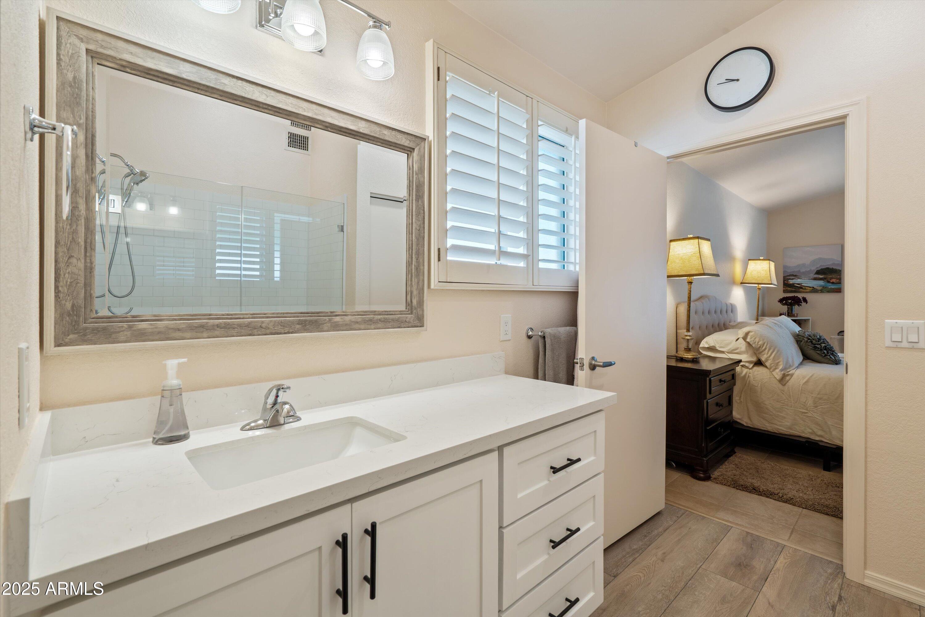15415 West Merrell Street Goodyear, AZ 85395 - Photo 14 of 33 a en suite bathroom with a double vanity sink and a mirror