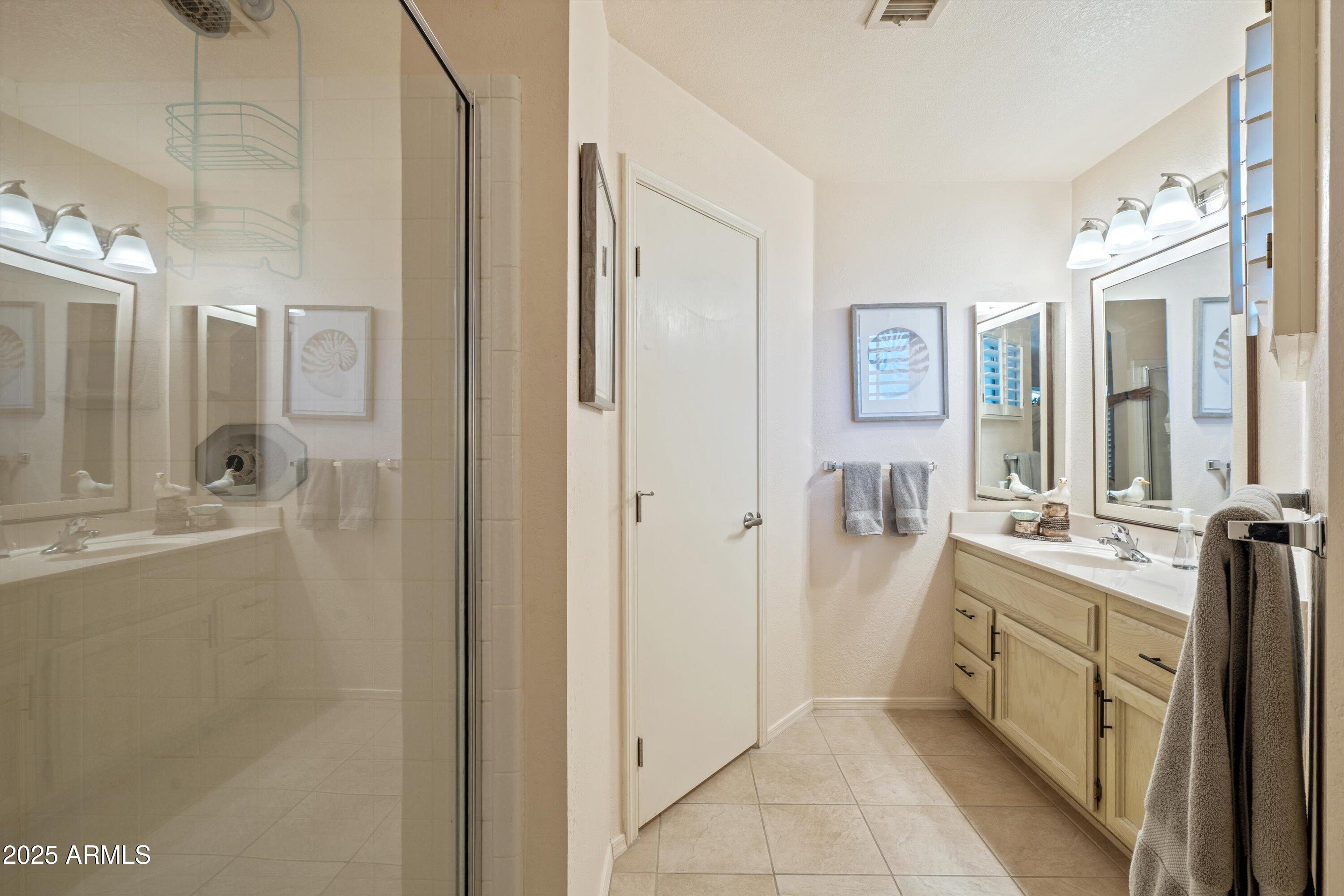 15415 West Merrell Street Goodyear, AZ 85395 - Photo 16 of 33 a spacious bathroom with a double vanity sink a mirror and a shower