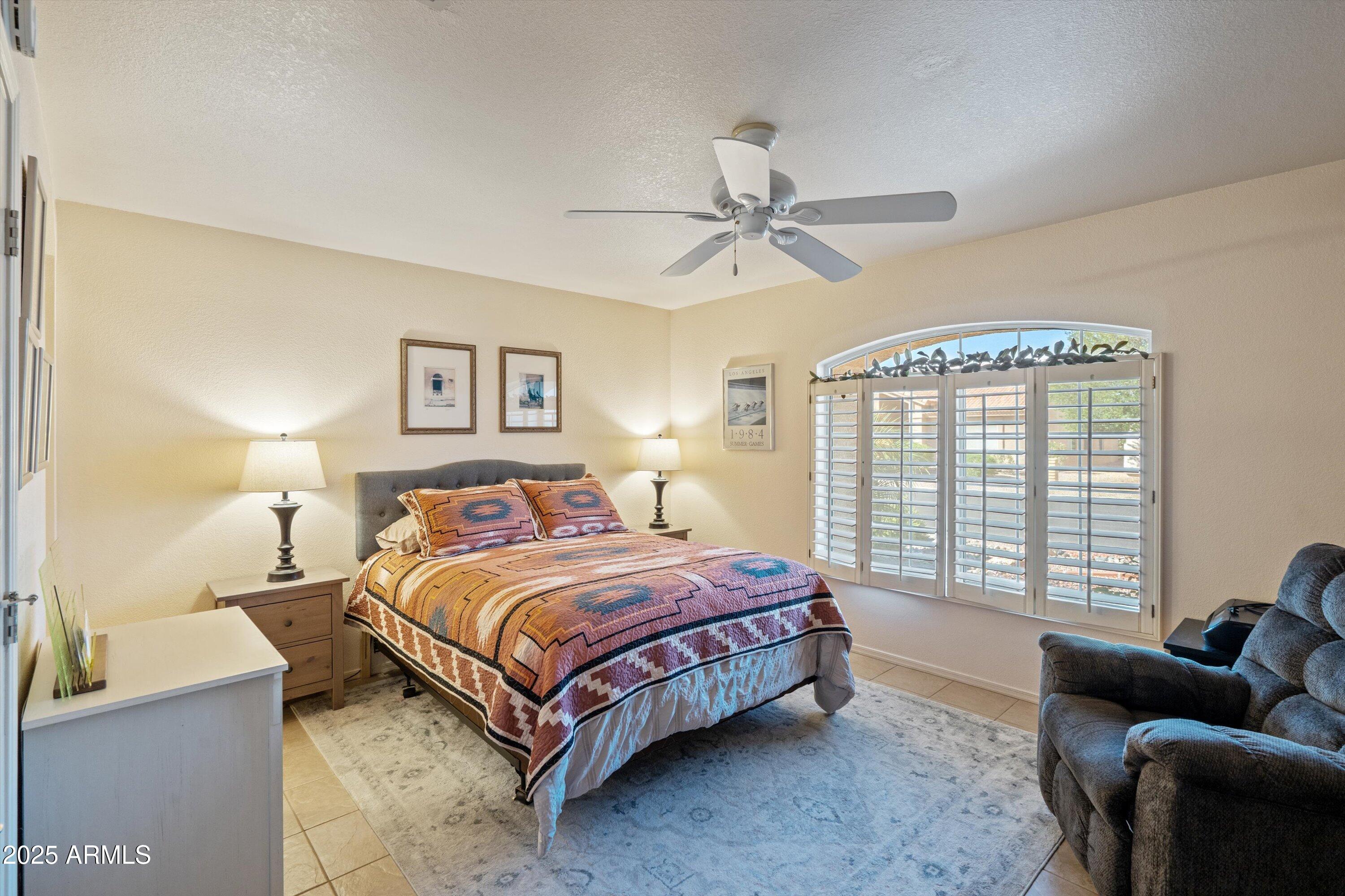 15415 West Merrell Street Goodyear, AZ 85395 - Photo 18 of 33 a bedroom with a bed couch and window