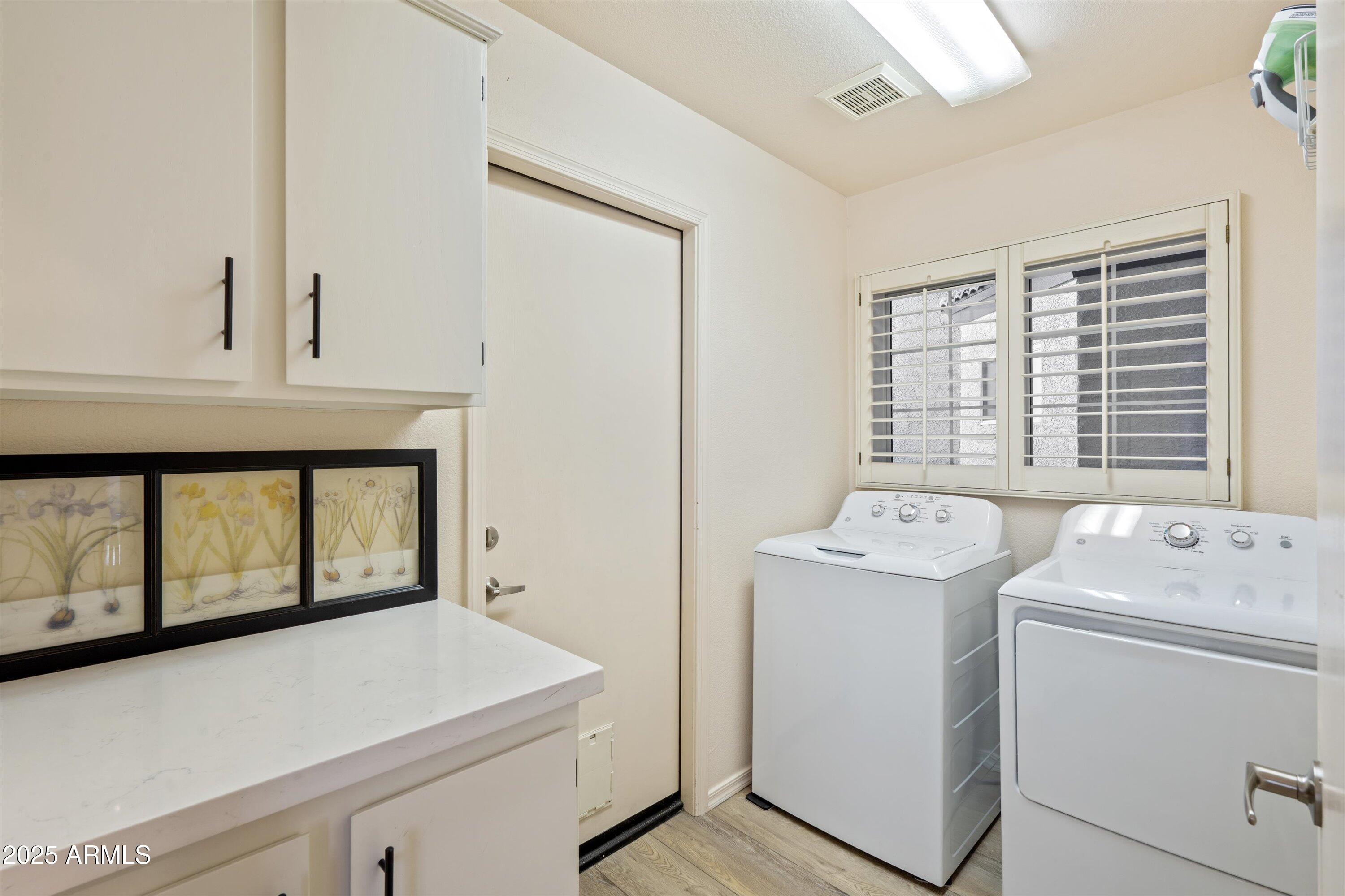 15415 West Merrell Street Goodyear, AZ 85395 - Photo 19 of 33 a view of washer and dryer with bathroom in the background