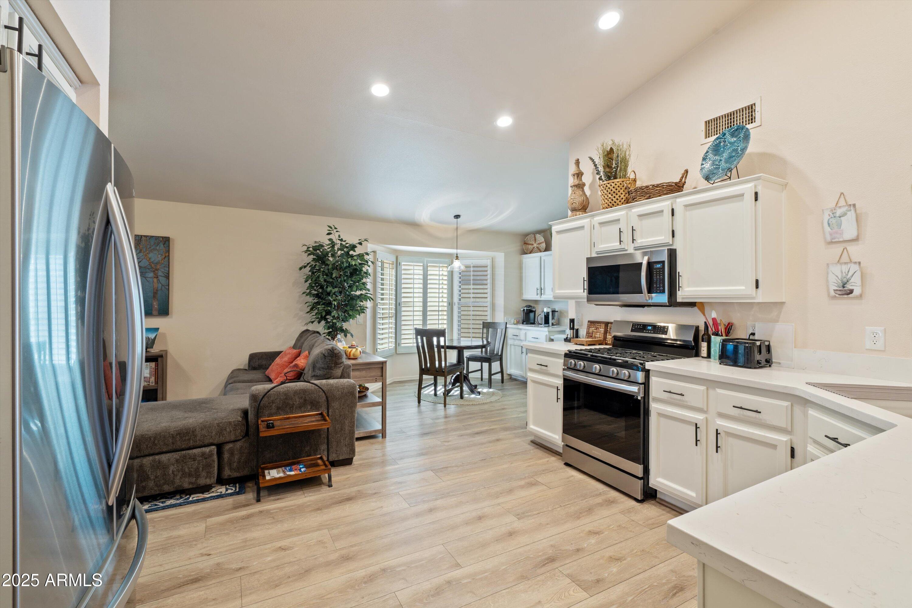 15415 West Merrell Street Goodyear, AZ 85395 - Photo 5 of 33 a kitchen with stainless steel appliances a stove a sink and a refrigerator