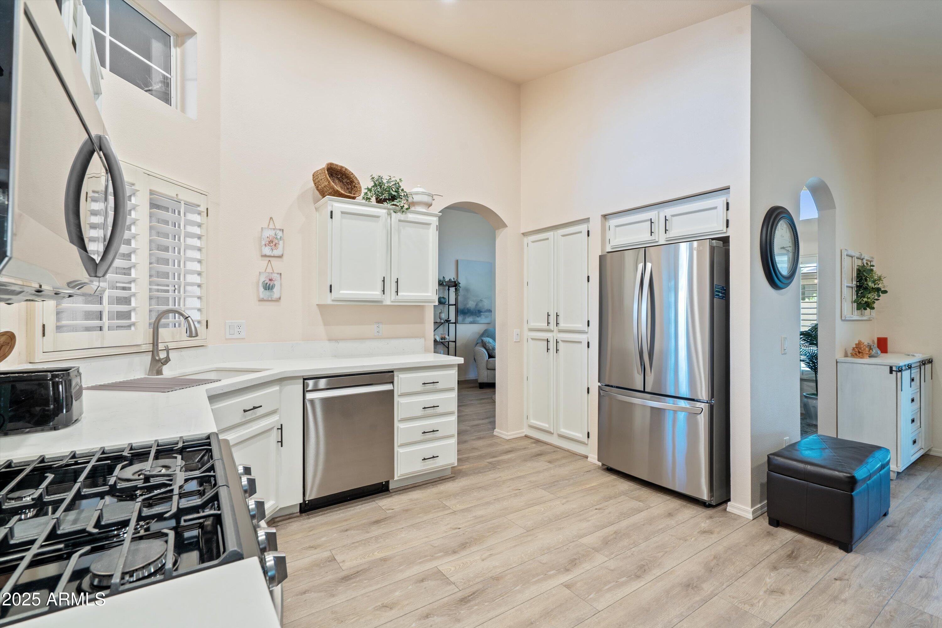 15415 West Merrell Street Goodyear, AZ 85395 - Photo 7 of 33 a kitchen with a refrigerator and a stove top oven