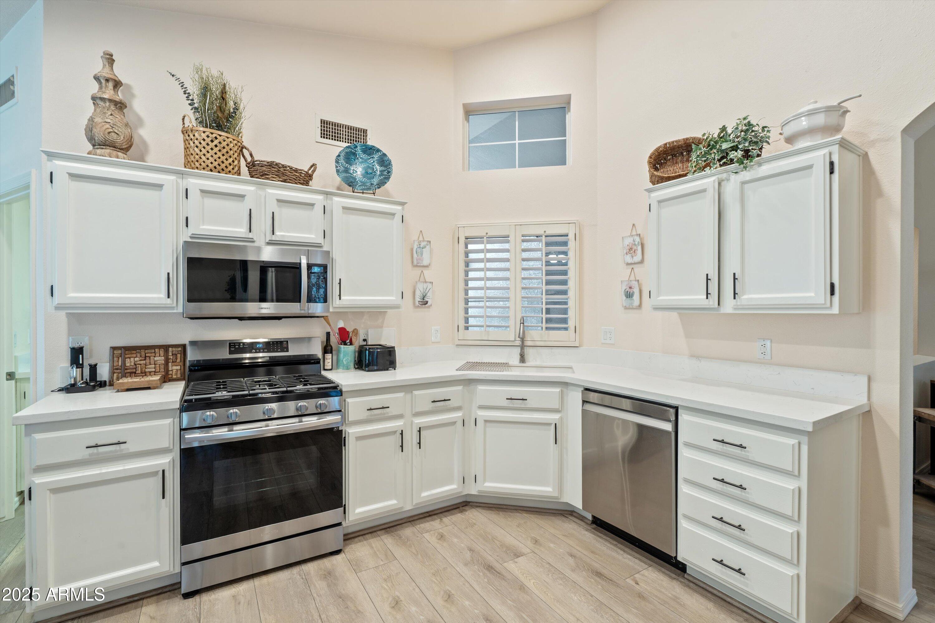 15415 West Merrell Street Goodyear, AZ 85395 - Photo 8 of 33 a kitchen with cabinets stainless steel appliances and wooden floor