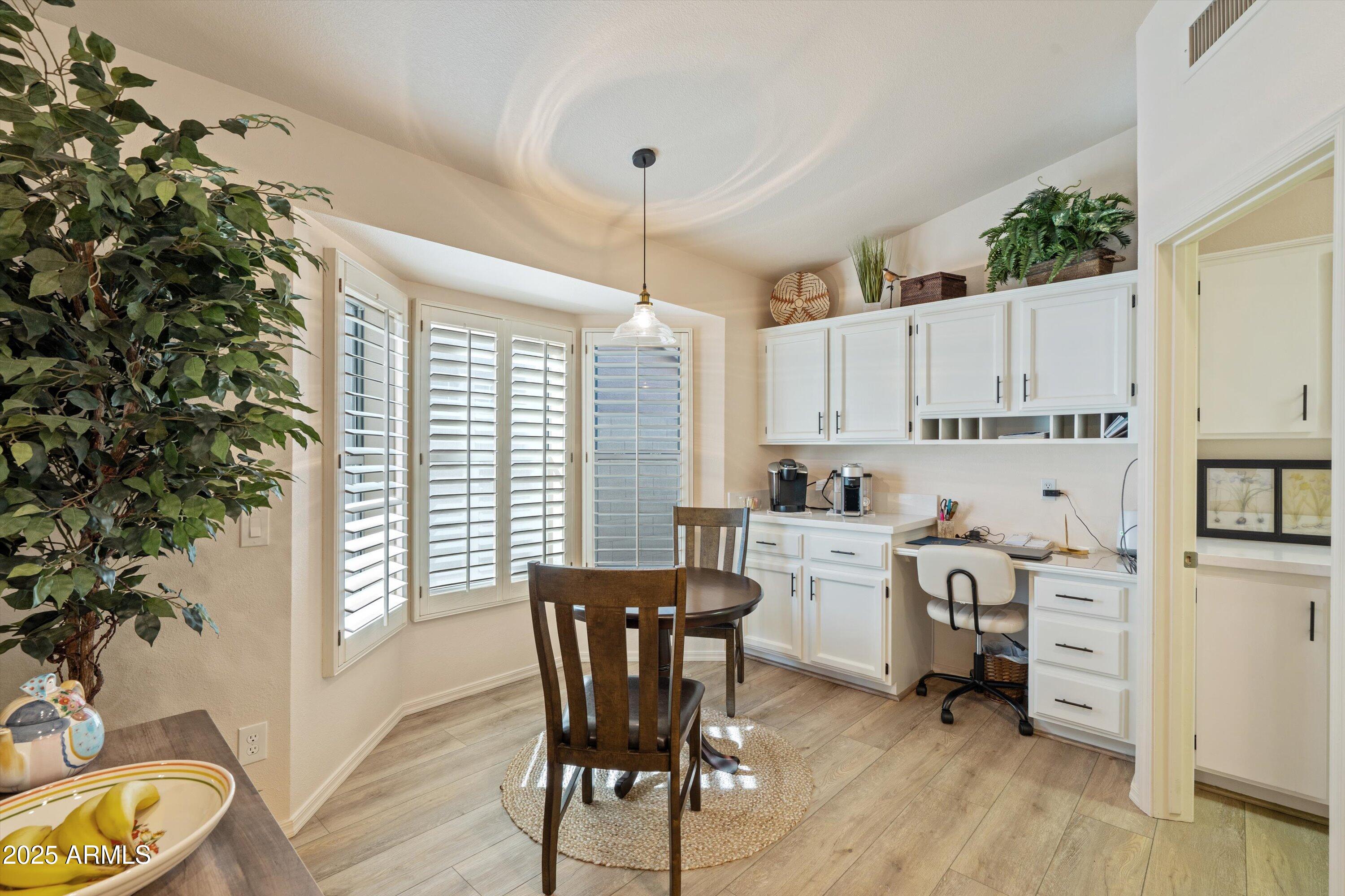 15415 West Merrell Street Goodyear, AZ 85395 - Photo 9 of 33 a kitchen with white cabinets and wooden floor