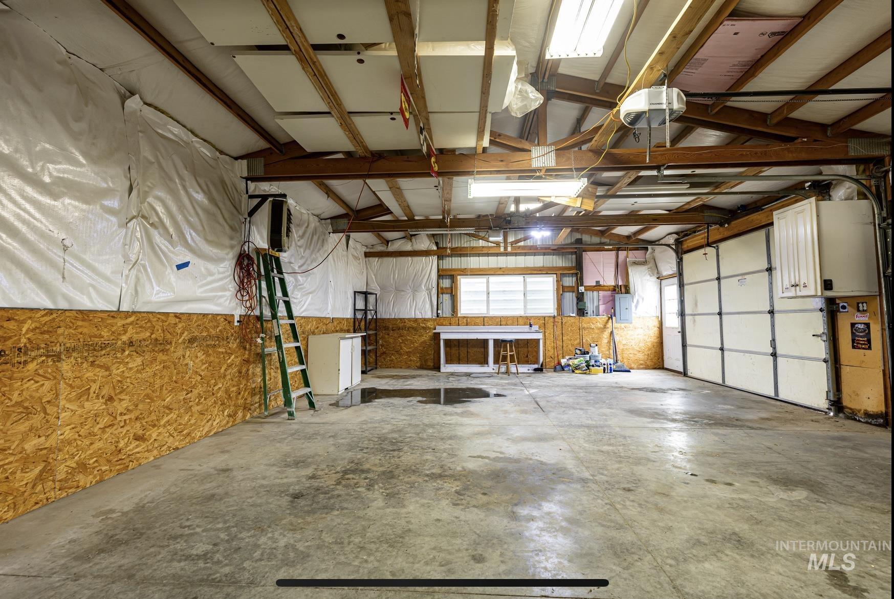17028 Lower Pleasant Ridge Road Caldwell, ID 83607 - Photo 20 of 21 Spacious garage featuring a concrete floor, exposed wood beam ceiling, and two overhead garage doors