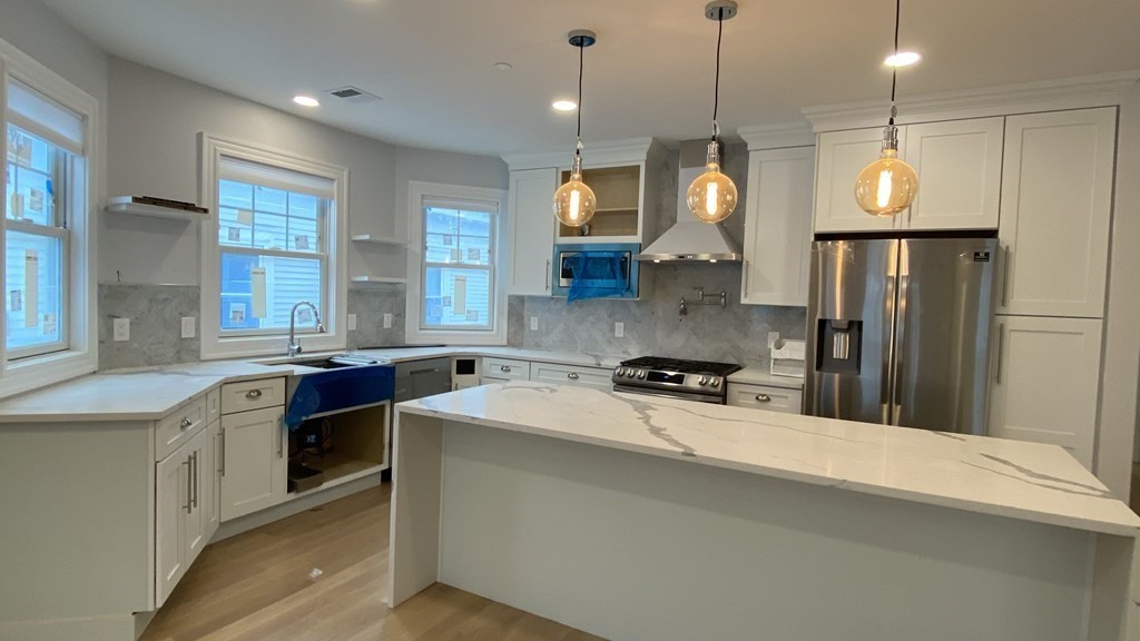 a kitchen with a sink a stove a refrigerator and dining table