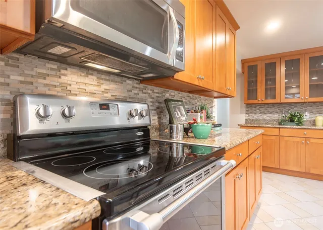 a kitchen with a stove a sink and cabinets