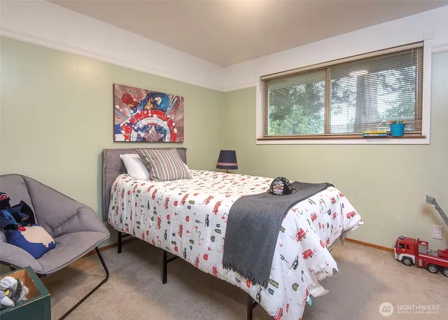 a bedroom with a bed and a painting on the wall