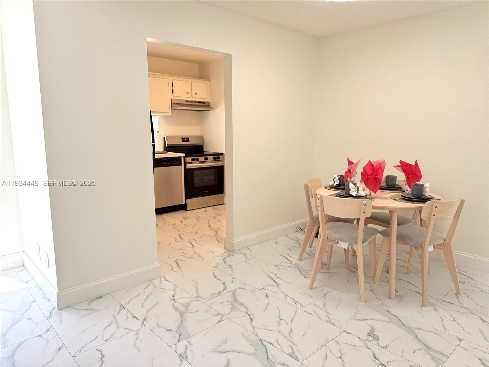 16909 North Bay Road, Unit 519 Sunny Isles Beach, FL 33160 - Photo 3 of 11 a dining room with furniture and a kitchen view