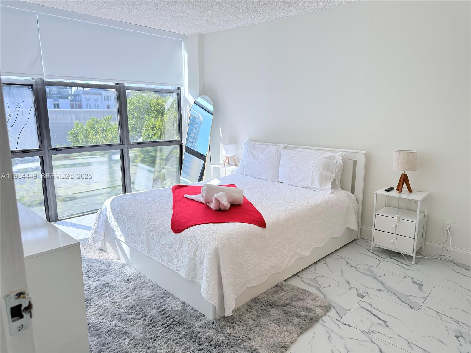 16909 North Bay Road, Unit 519 Sunny Isles Beach, FL 33160 - Photo 5 of 11 a bedroom with a large bed and a large window