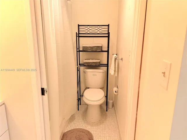a white toilet sitting next to a shower