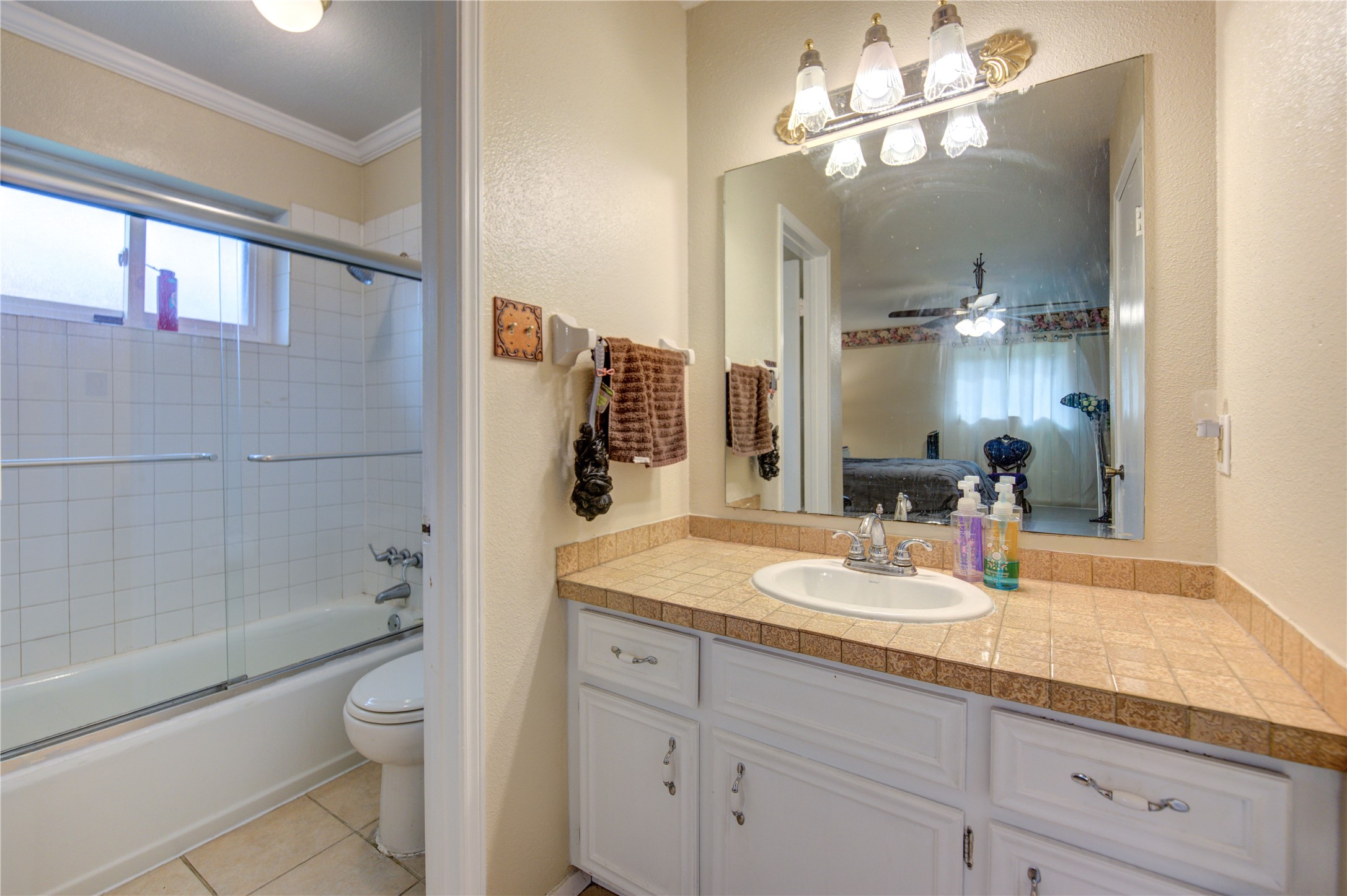 1403 Packsaddle Lane Baytown, TX 77521 - Photo 16 of 19 a bathroom with a granite countertop sink a toilet a mirror and shower
