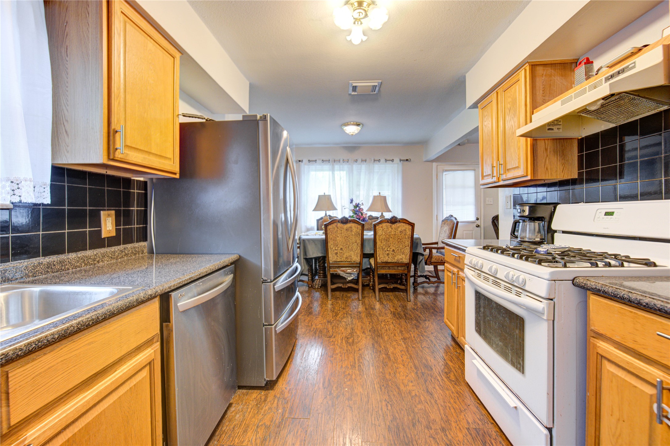 1403 Packsaddle Lane Baytown, TX 77521 - Photo 9 of 19 a kitchen with stainless steel appliances granite countertop sink stove top oven and cabinets