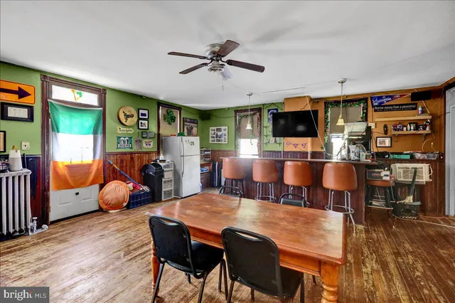 a living room with furniture a clock on wall and a window