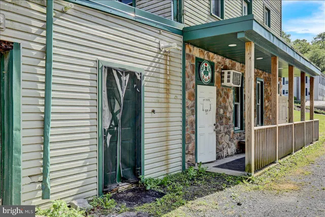 a view of a house with a door and a tree