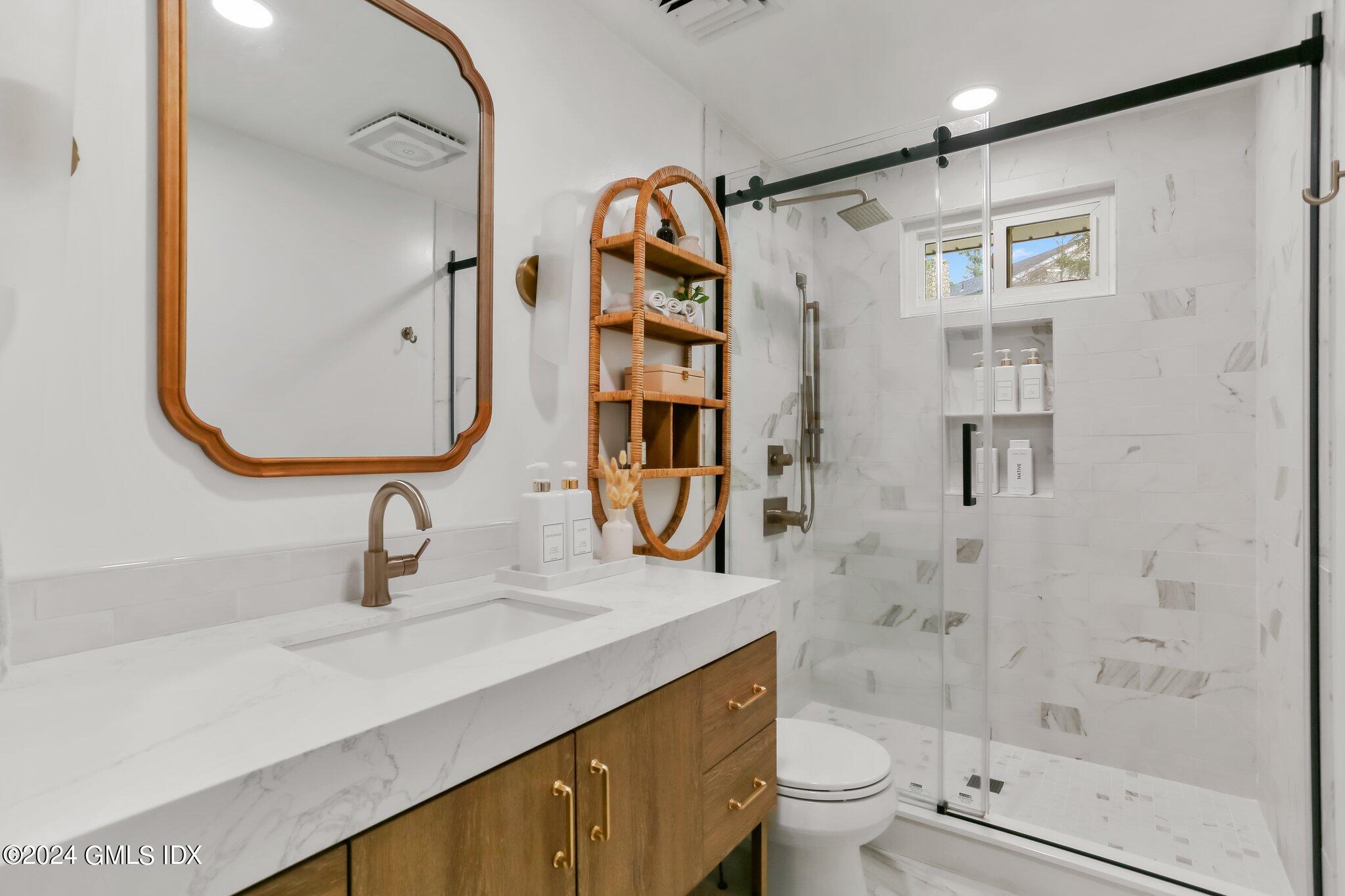 565 River Road Cos Cob, CT 06870 - Photo 14 of 29 a bathroom with a sink a toilet and shower