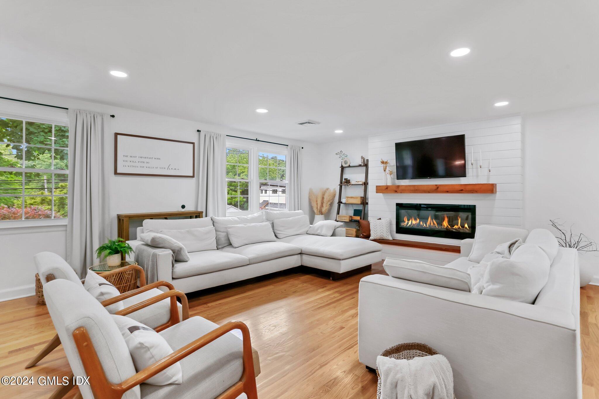 565 River Road Cos Cob, CT 06870 - Photo 4 of 29 a living room with furniture a fireplace and a flat screen tv