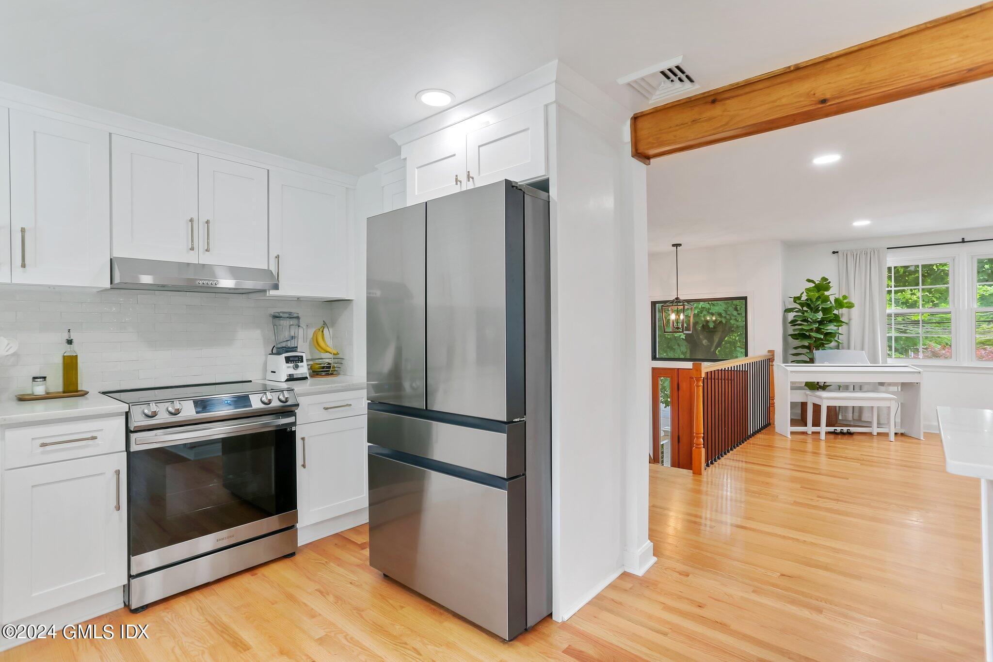 565 River Road Cos Cob, CT 06870 - Photo 9 of 29 a kitchen with stainless steel appliances a stove a refrigerator and a fireplace