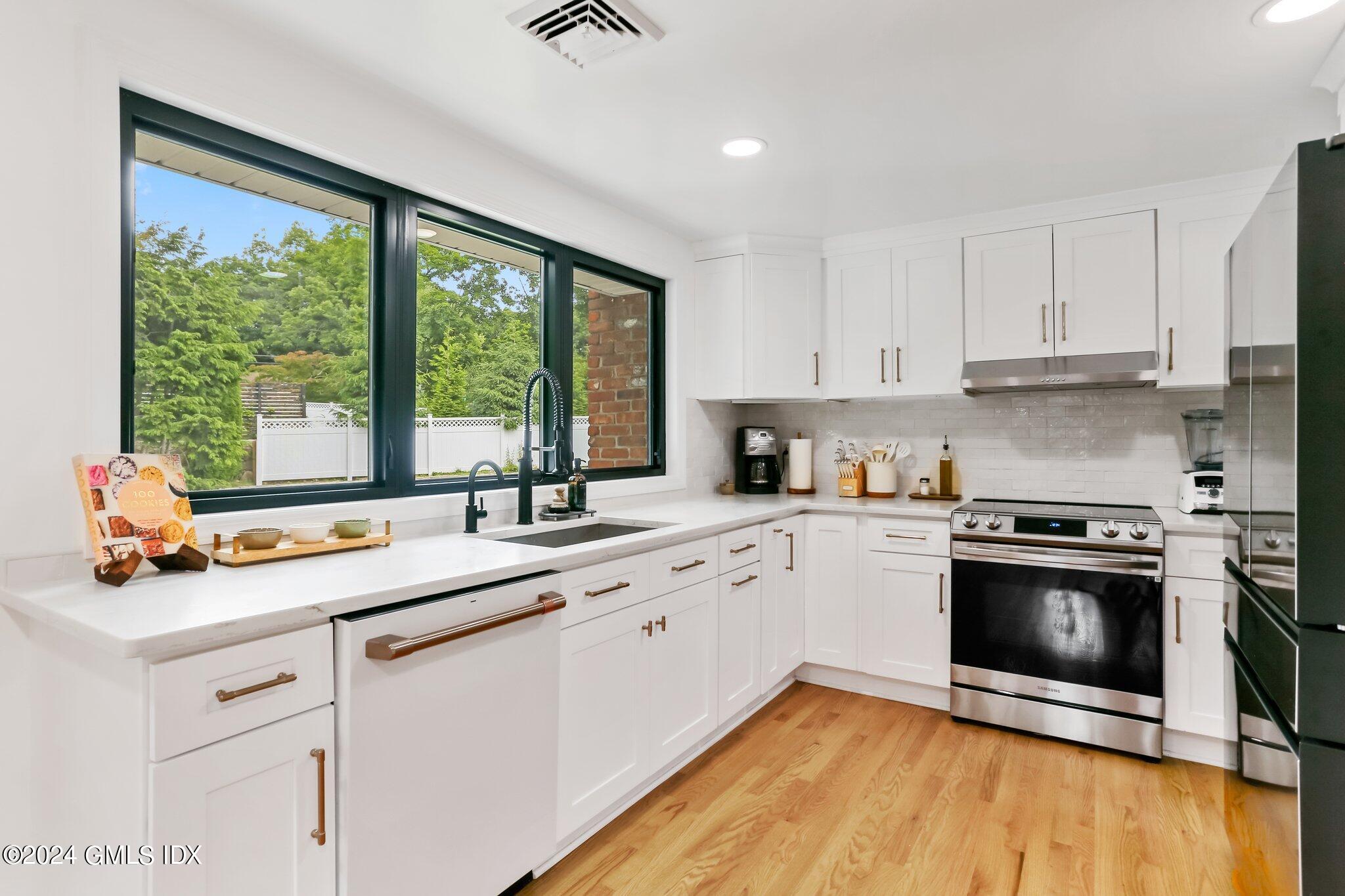 565 River Road Cos Cob, CT 06870 - Photo 10 of 29 a kitchen with stainless steel appliances white cabinets a sink and a stove