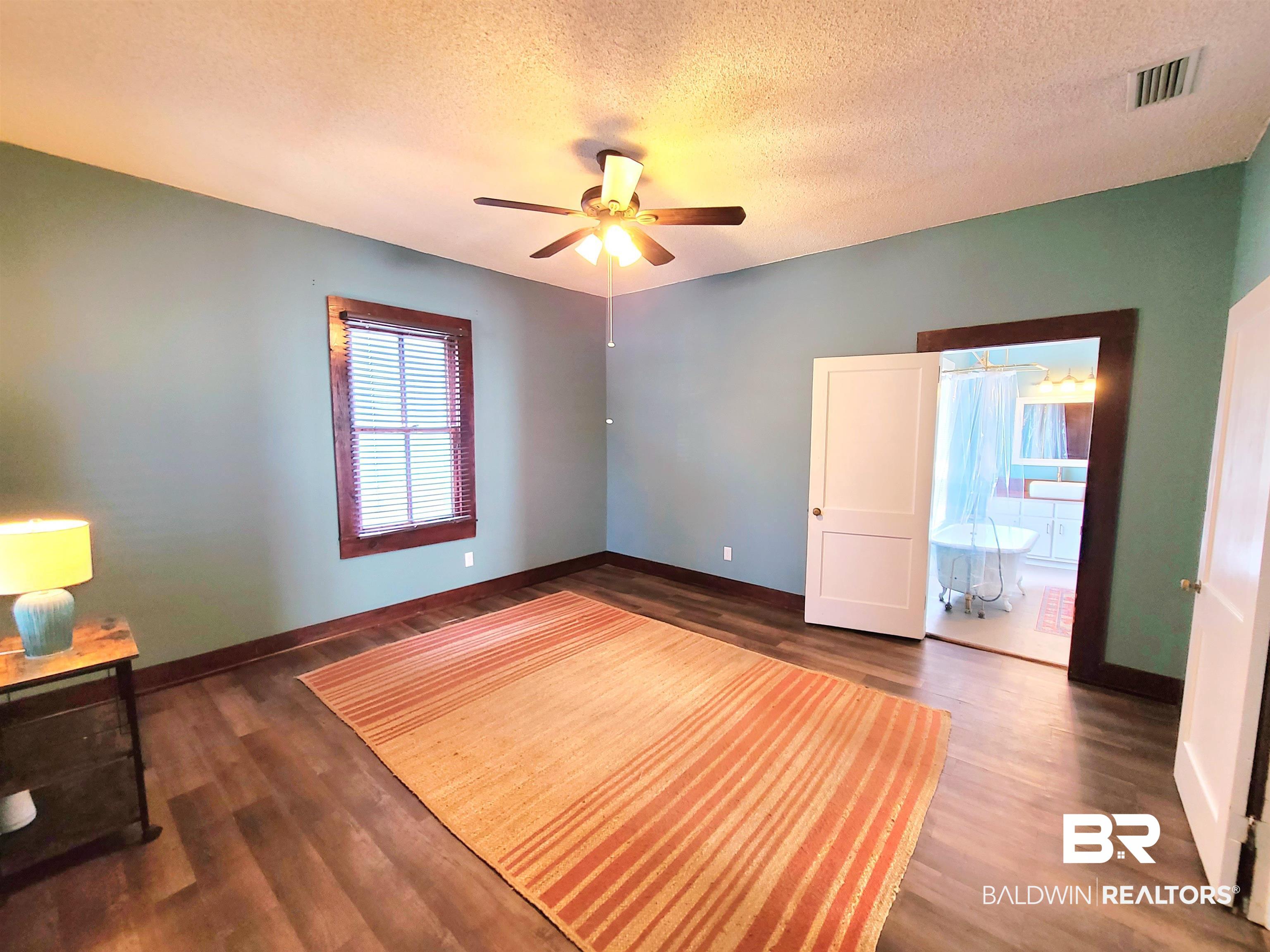 112 Espejo Street Mobile, AL 36604 - Photo 10 of 20 Unfurnished bedroom featuring a ceiling fan, visible vents, baseboards, a textured ceiling, and wood finished floors