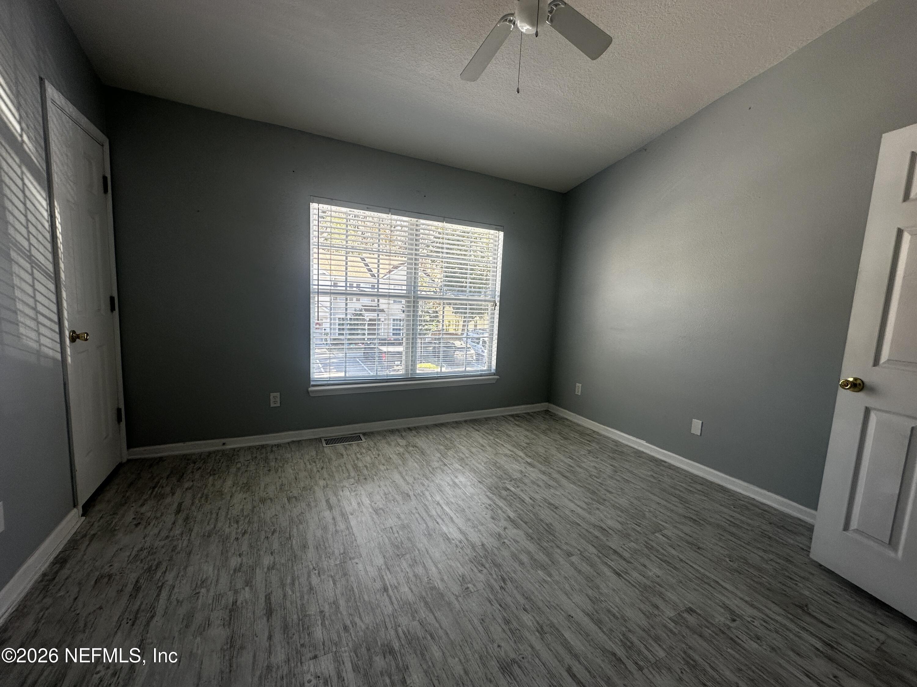 3548 Lone Tree Lane Jacksonville, FL 32216 - Photo 2 of 10 an empty room with wooden floor and windows