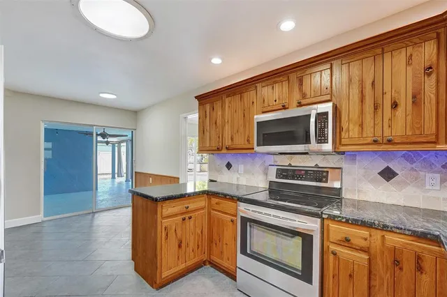 a kitchen with stainless steel appliances granite countertop a stove microwave and sink