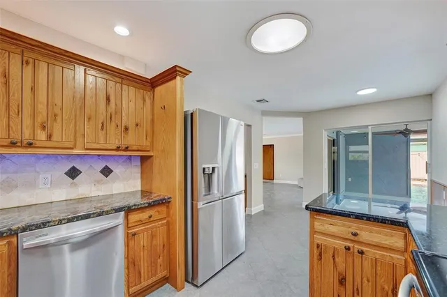 a kitchen with stainless steel appliances granite countertop a refrigerator and a sink