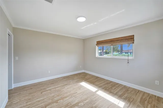 a view of empty room with wooden floor