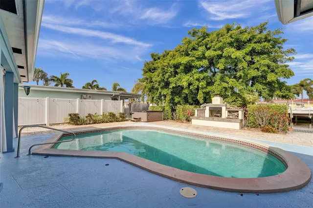 a view of a swimming pool with a patio and a yard
