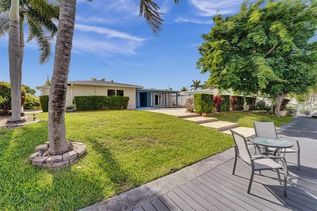 a view of a house with backyard sitting area and garden