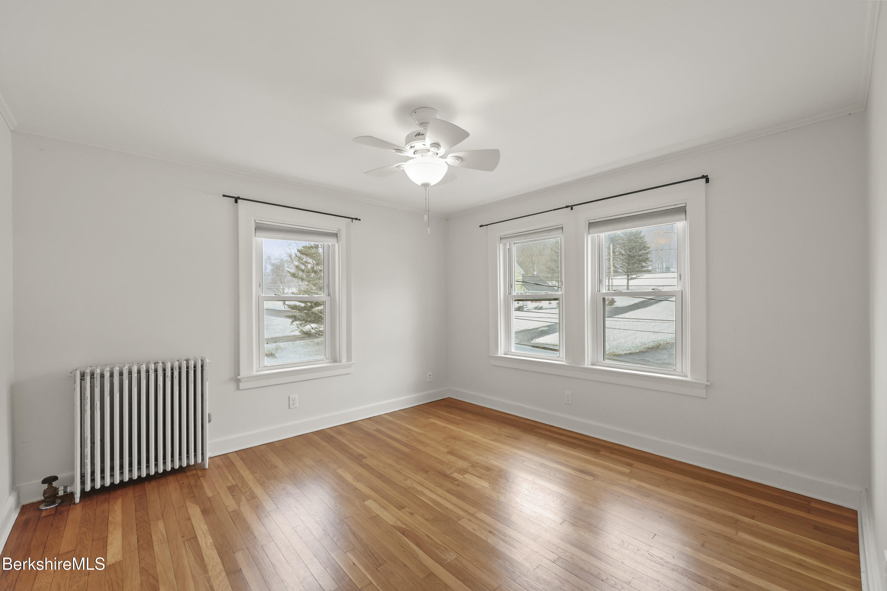 155 Laurel Street Lee, MA 01238 - Photo 29 of 43 an empty room with wooden floor chandelier fan and windows