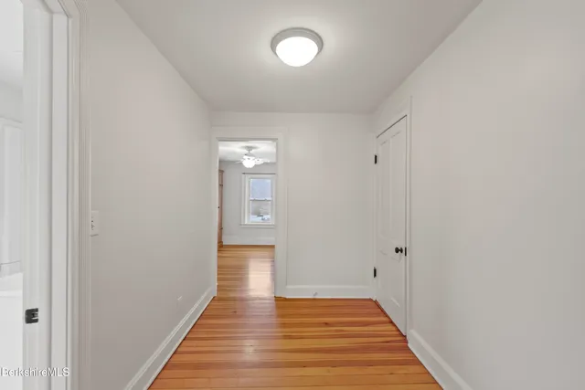 a view of a hallway with wooden floor