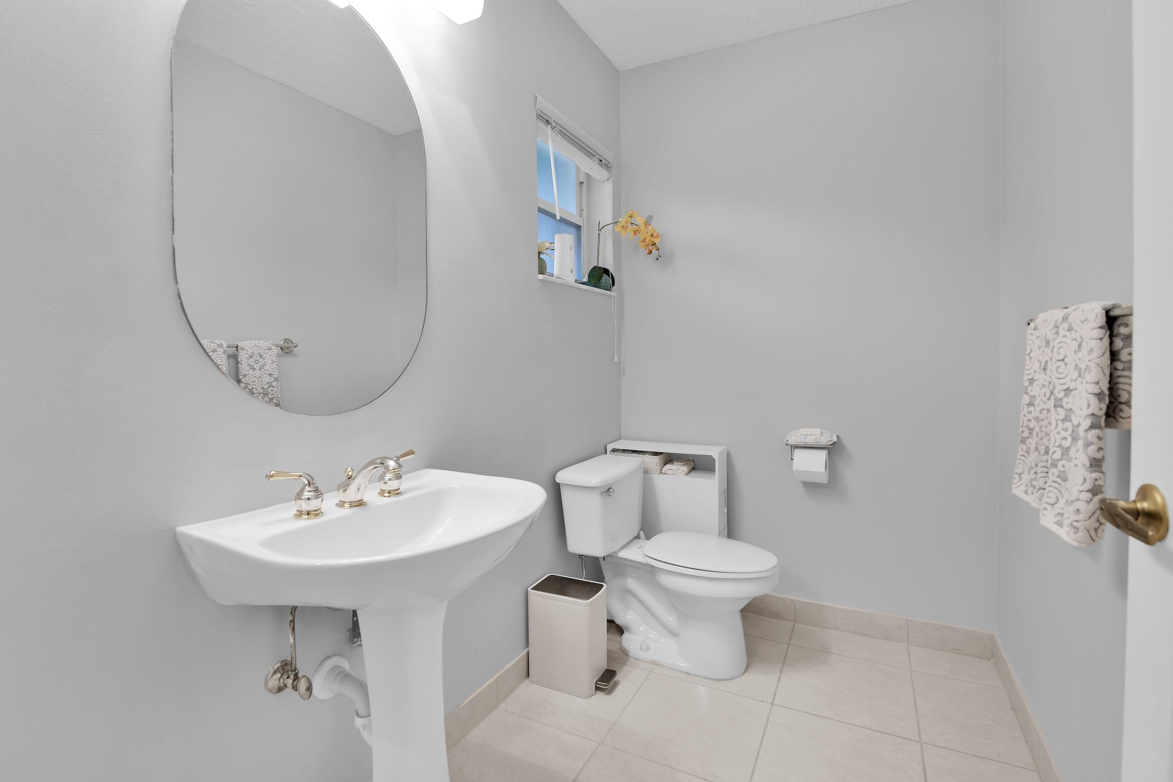 7458 Falls Road West Boynton Beach, FL 33437 - Photo 13 of 45 a bathroom with a sink toilet and a mirror