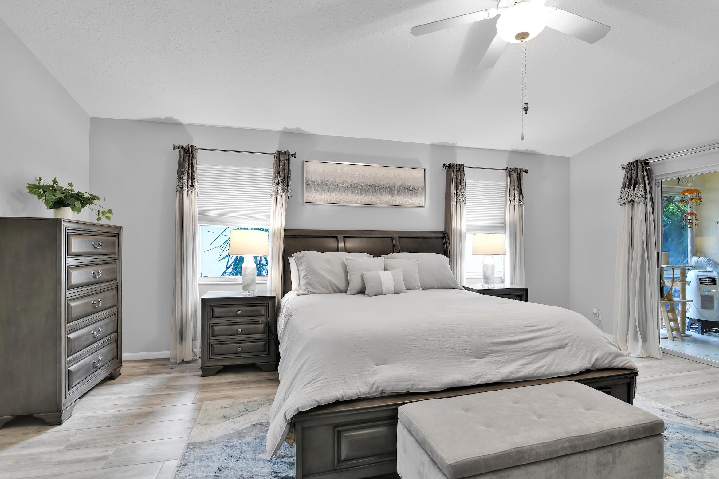 7458 Falls Road West Boynton Beach, FL 33437 - Photo 19 of 45 a bedroom with a bed and a chandelier