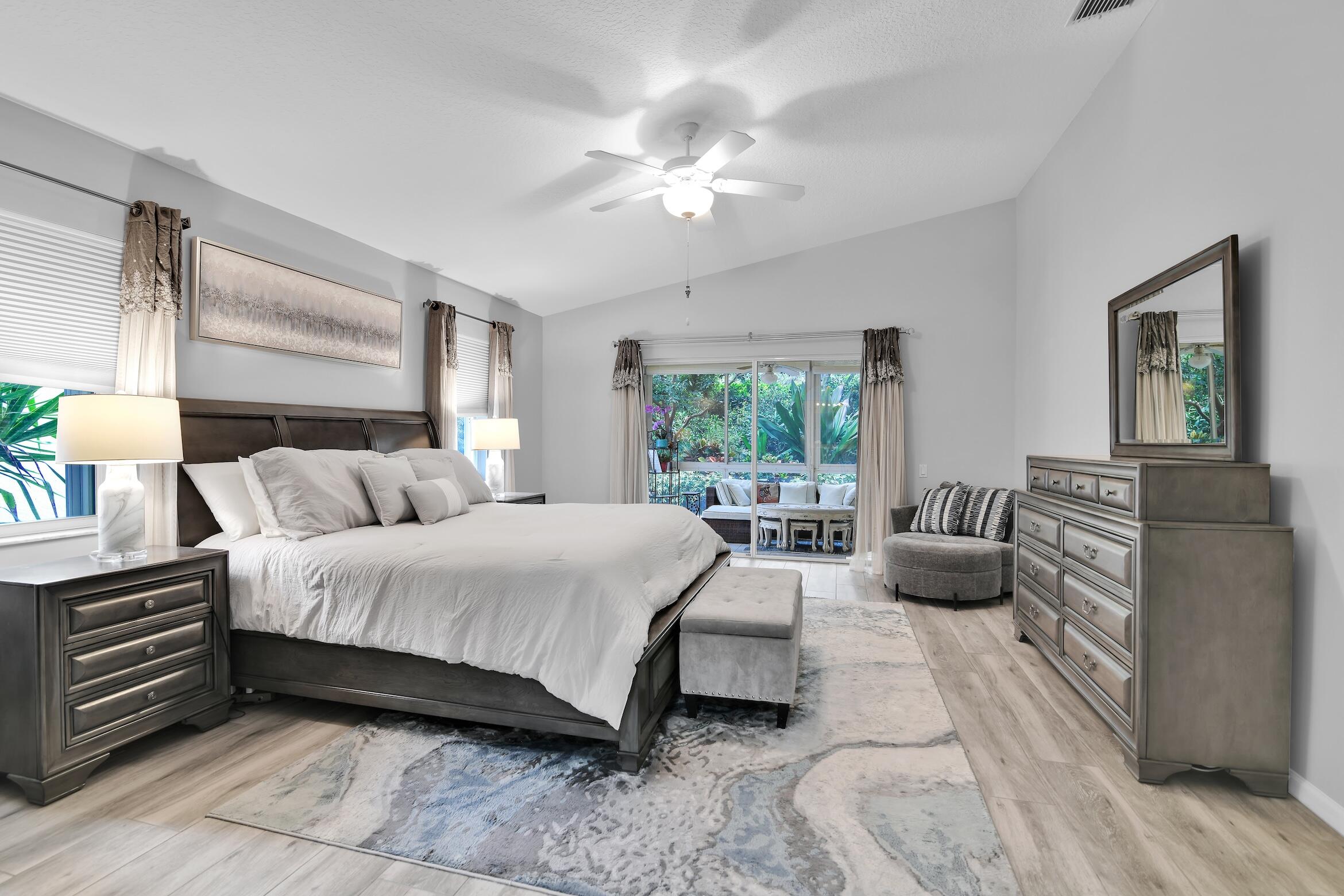 7458 Falls Road West Boynton Beach, FL 33437 - Photo 20 of 45 a spacious bedroom with a bed a couch and a large window