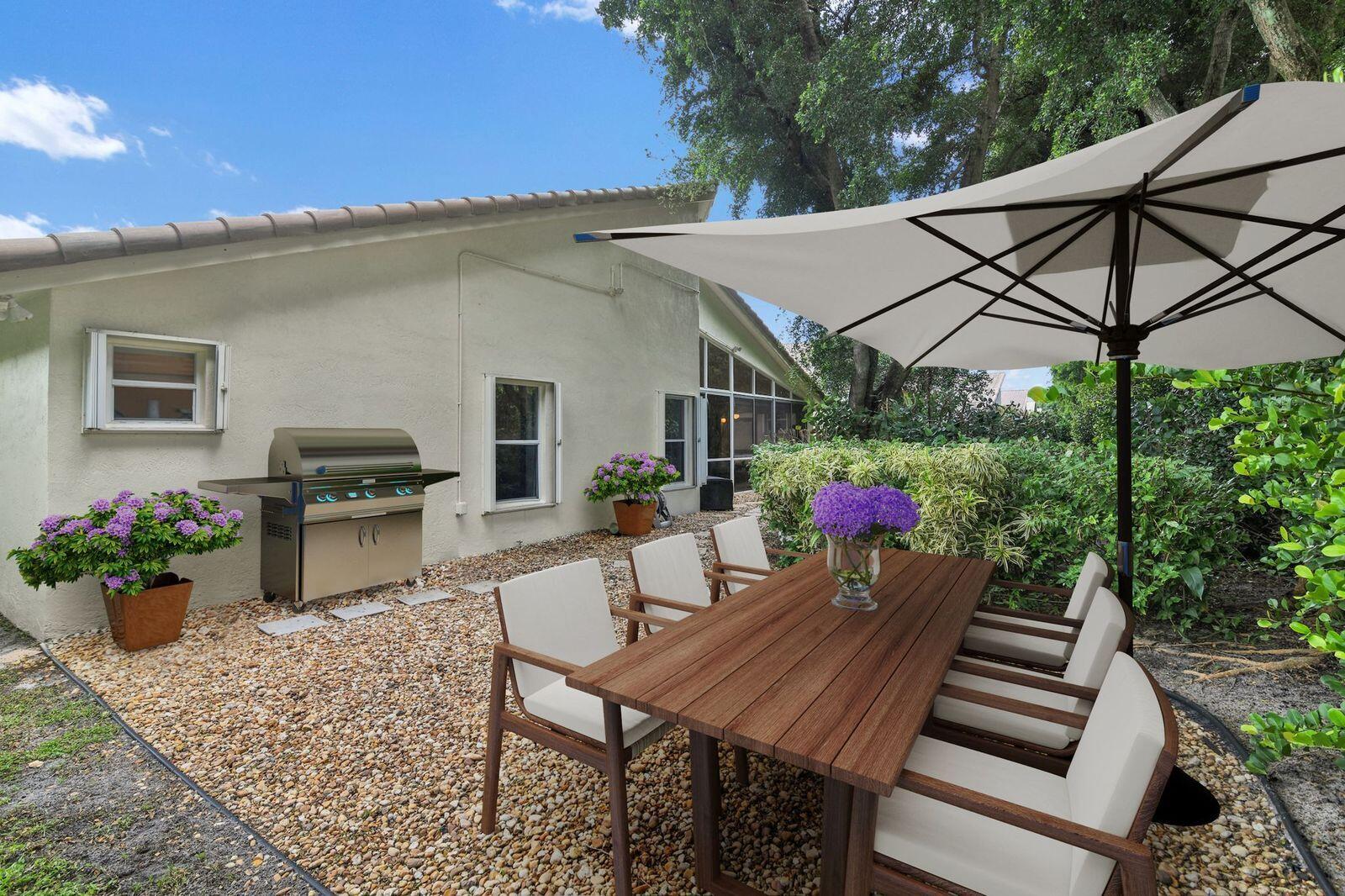 7458 Falls Road West Boynton Beach, FL 33437 - Photo 32 of 45 a view of a patio with table and chairs potted plants with wooden floor and fence