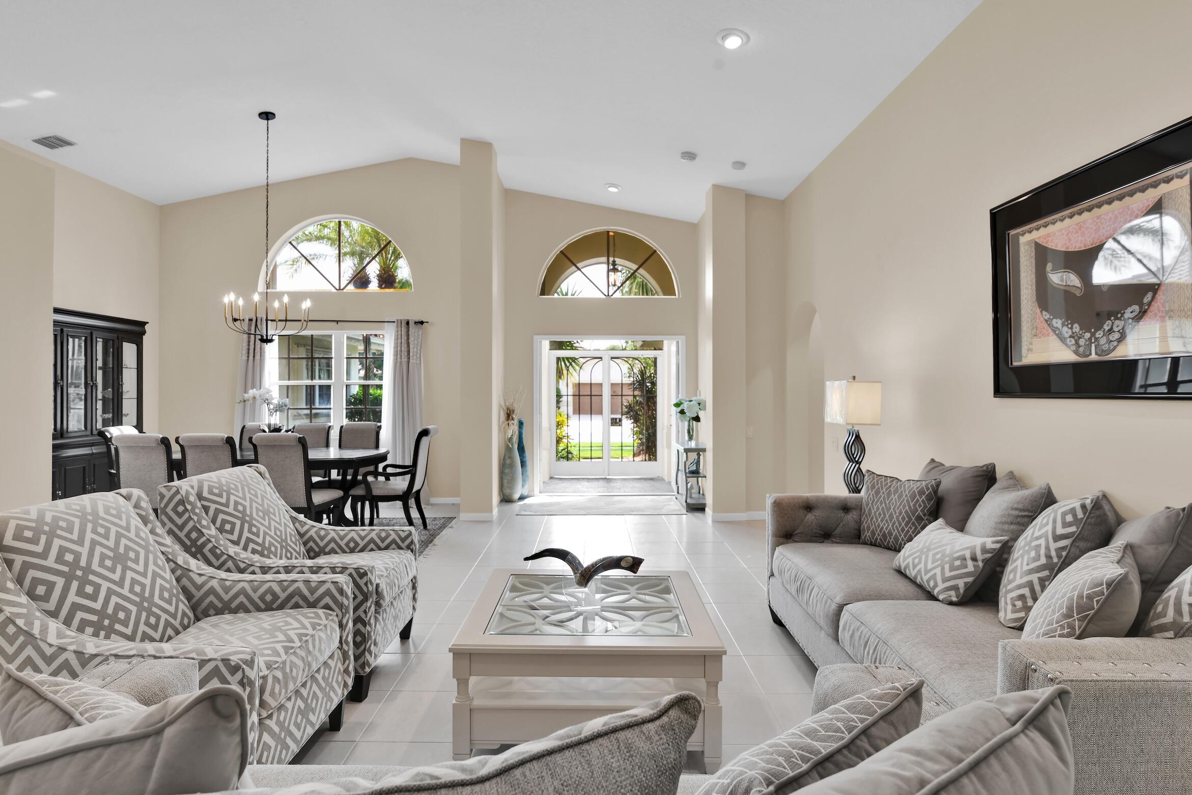 7458 Falls Road West Boynton Beach, FL 33437 - Photo 5 of 45 a living room with furniture a large window and a chandelier